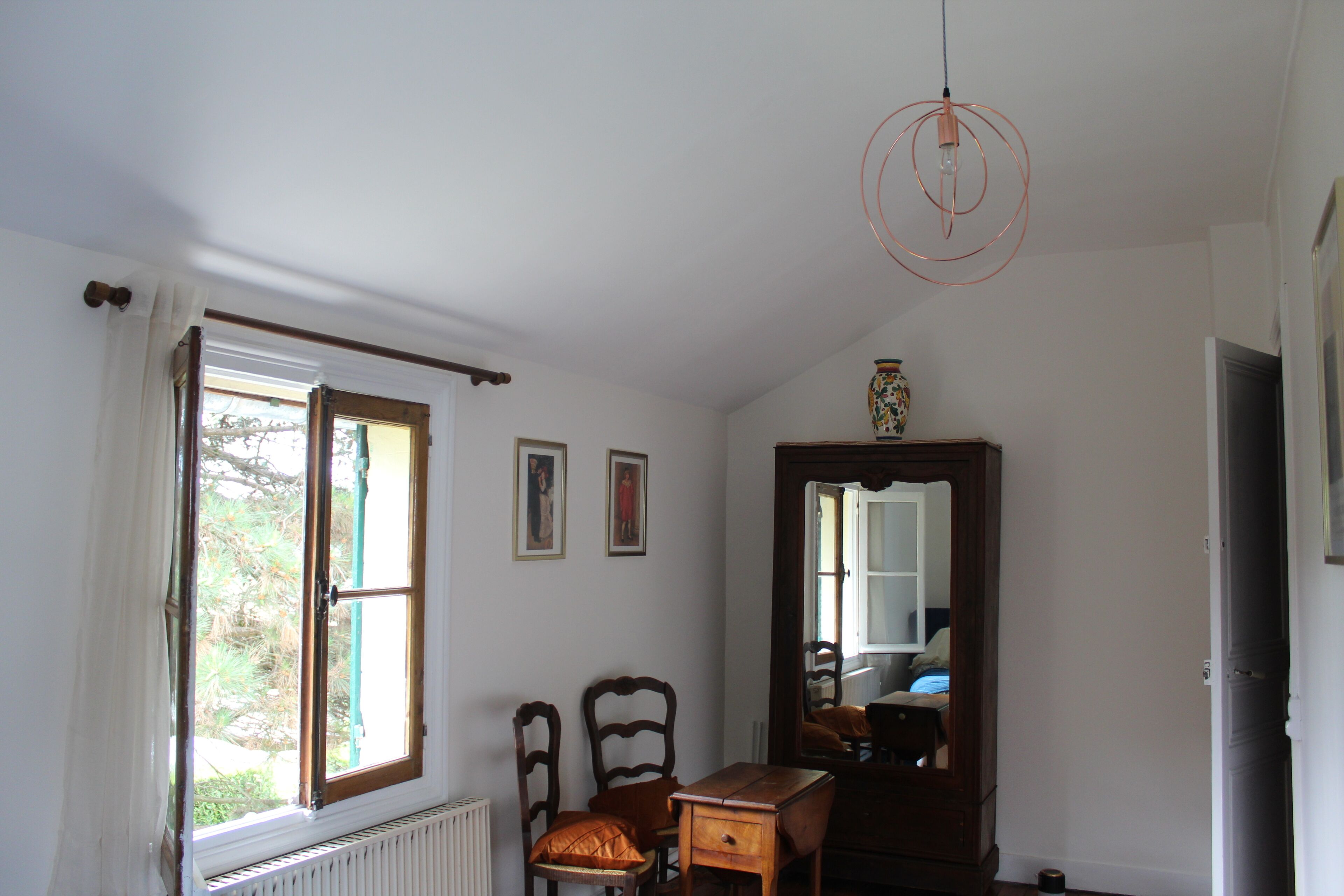 Una stanza con un grande specchio, arredi in legno e un termosifone.