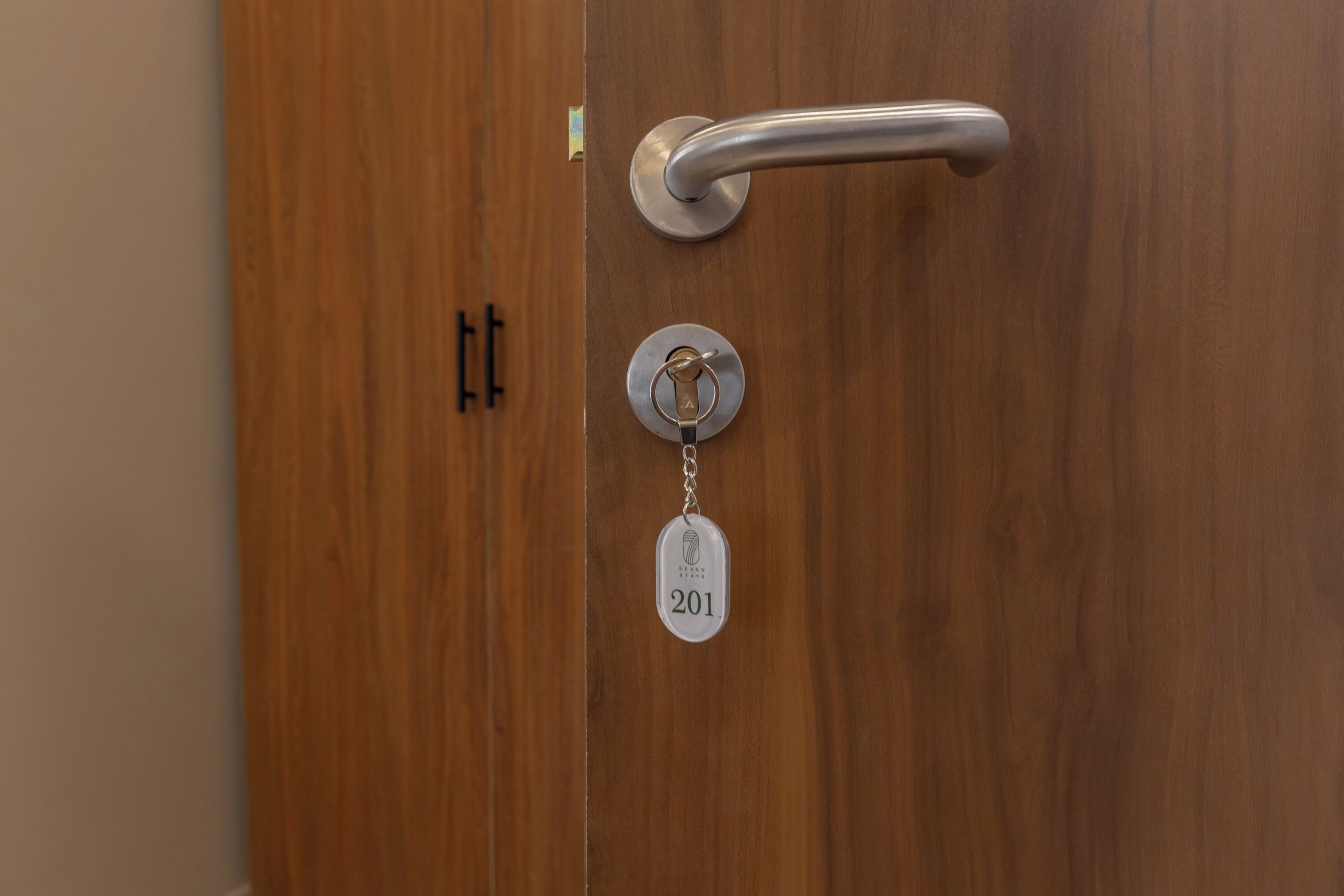 A wooden door with a silver handle and a keycard lock.