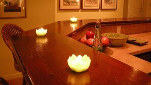 A dining table with candles, fruit, and a vase. There are framed pictures on the wall. - Beachfront Paradise! Dog friendly 3 bedroom condo! (Flagler Beach)