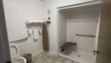 A bathroom with a toilet, a shower, and a sink.