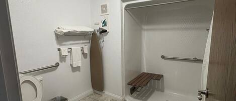 A bathroom with a toilet, a shower, and a sink.
