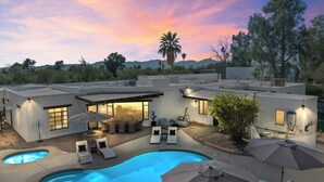Una casa moderna con piscina, mobiliario exterior y zona de patio.