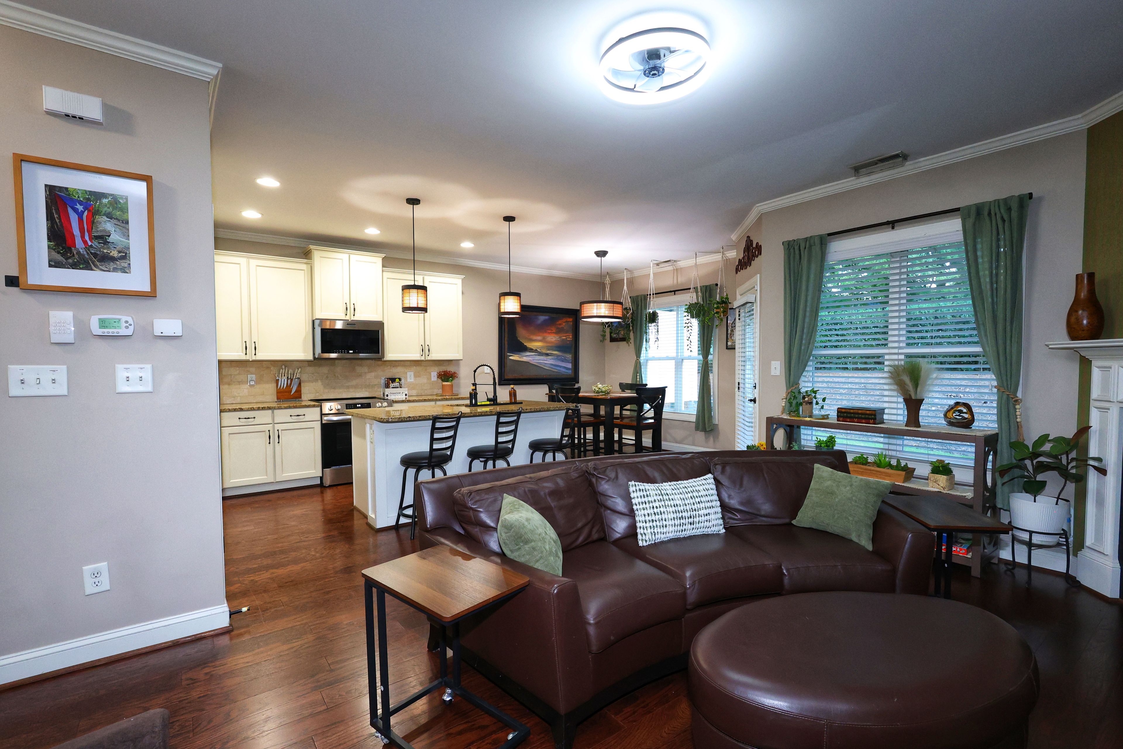 A modern kitchen with white cabinets, a central island, and bar seating.