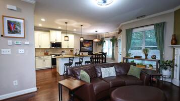 A modern kitchen with white cabinets, a central island, and bar seating.