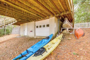 Un garage fermé où sont entreposés des kayaks et un bateau.