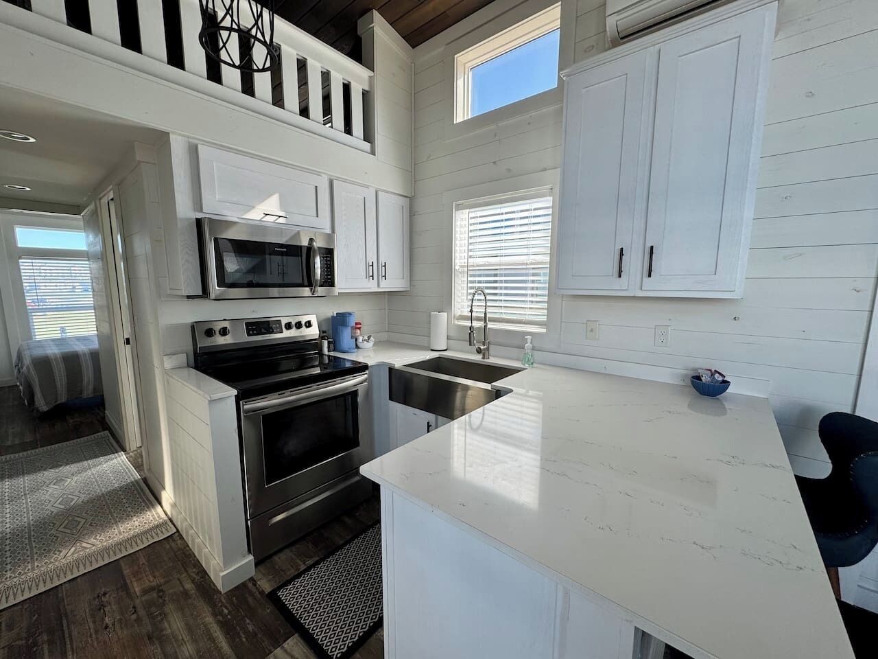 A modern kitchen with white cabinetry, stainless steel appliances, and a large island.