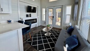 Un espace de vie compact comprenant une cuisine, un coin repas et un coin salon.