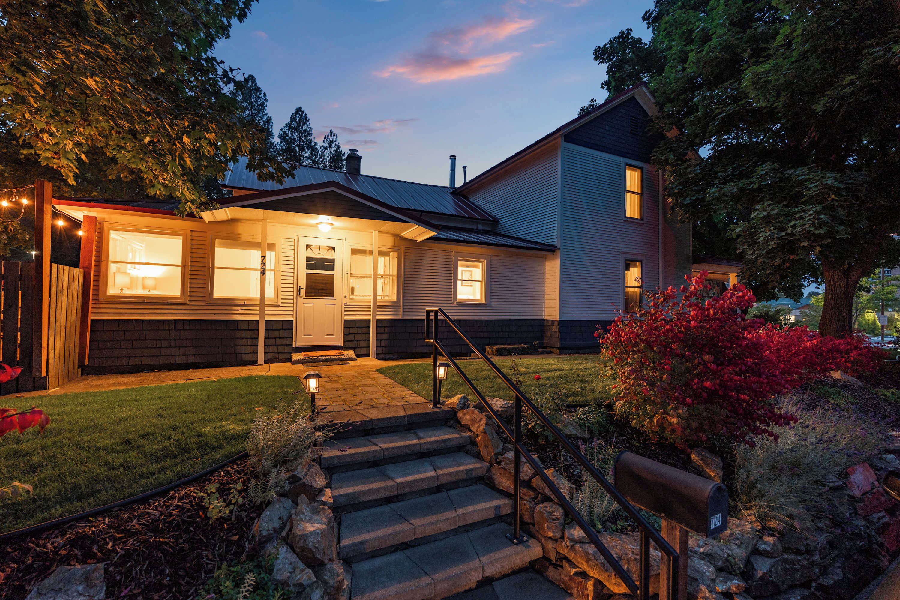A two-story house with a front porch, a mailbox, and a well-maintained lawn.