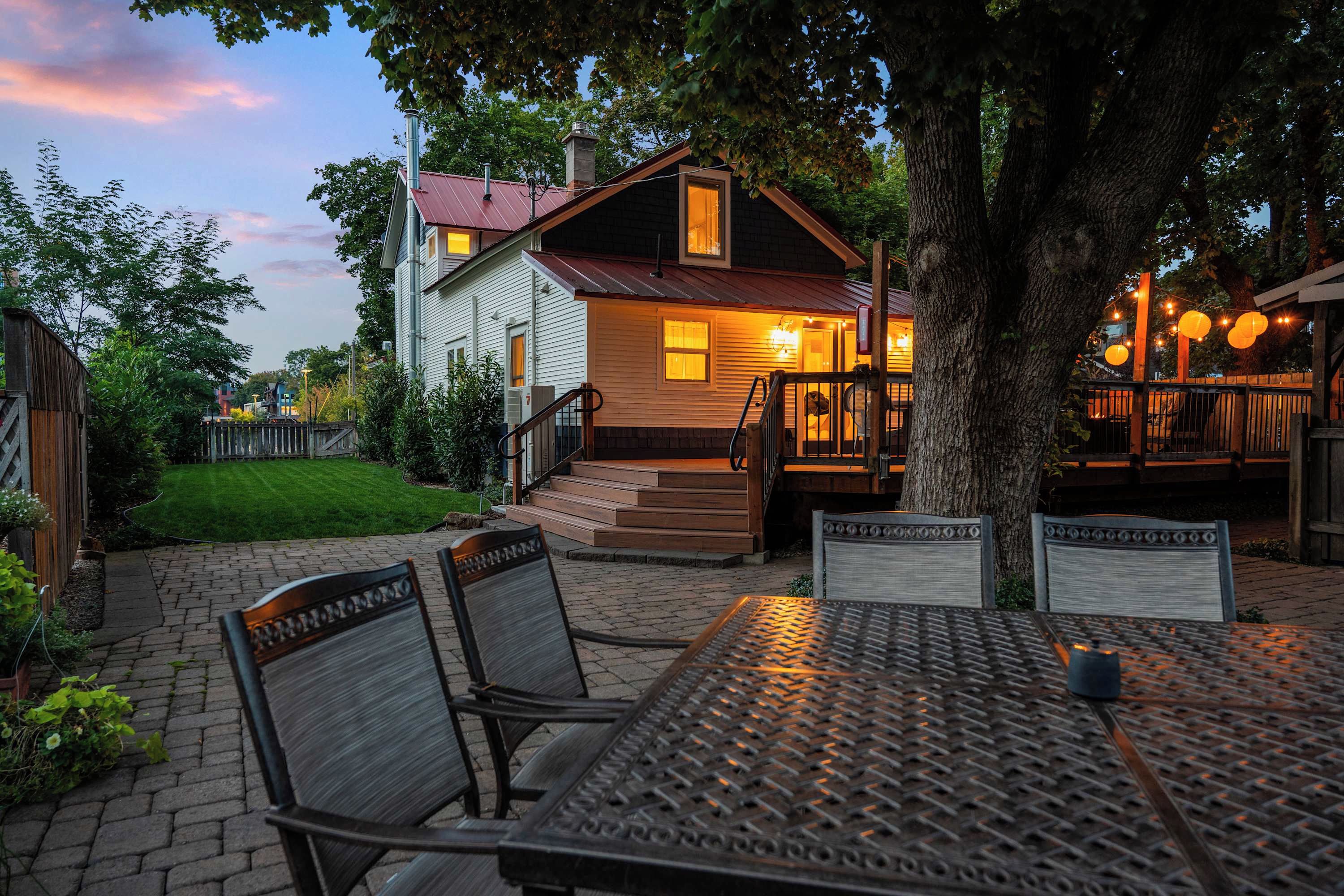 A house with a porch, outdoor seating, and a well-maintained lawn.