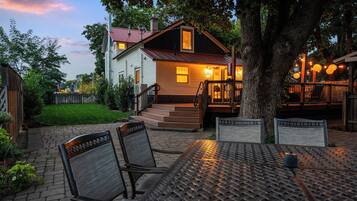 A house with a porch, outdoor seating, and a well-maintained lawn.