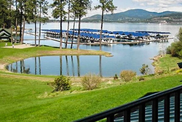 A lakeside property with a dock, a small boat, and a grassy area.