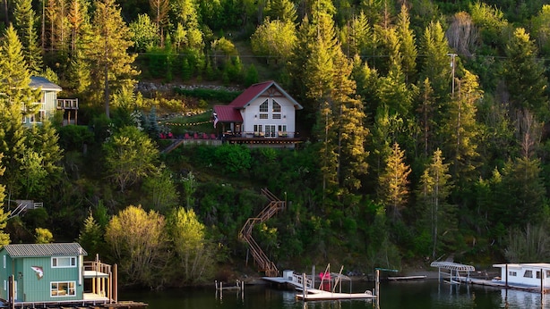 A lakeside cabin with a dock, surrounded by dense forest.