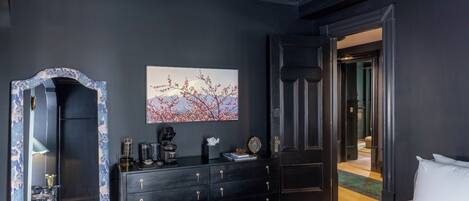Un dormitorio con cama, cómoda, espejo y un cuadro en la pared.