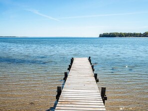 A wooden pier extending into calm water with a clear sky above. - 4 Star Holiday Home in Hejls (Hejls)