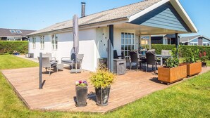 A modern house with a covered patio, outdoor furniture, and a garden area. - 4 Star Holiday Home in Hejls (Hejls)