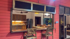 A kitchen with wooden cabinets, a refrigerator, and a dining area with a table and chairs.