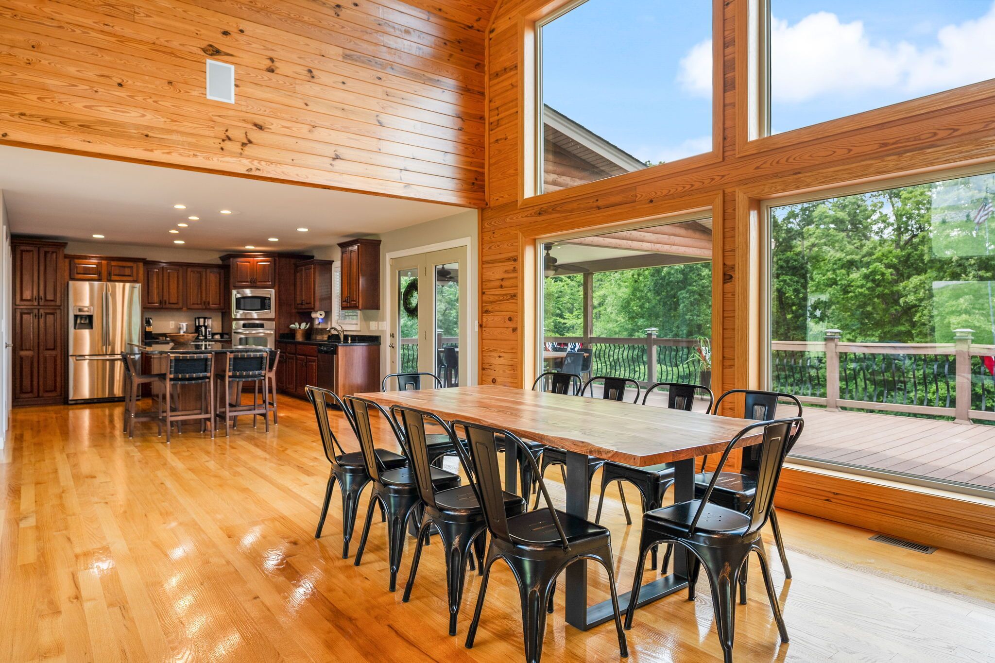 A spacious kitchen with wooden cabinets, stainless steel appliances, and a large dining table with chairs.