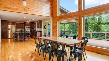 A spacious kitchen with wooden cabinets, stainless steel appliances, and a large dining table with chairs.