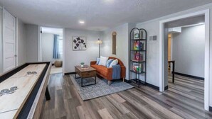 A modern living room with a pool table, a sofa, and a bookshelf. - Modern Midtown Getaway! Central location for 12! (Omaha)