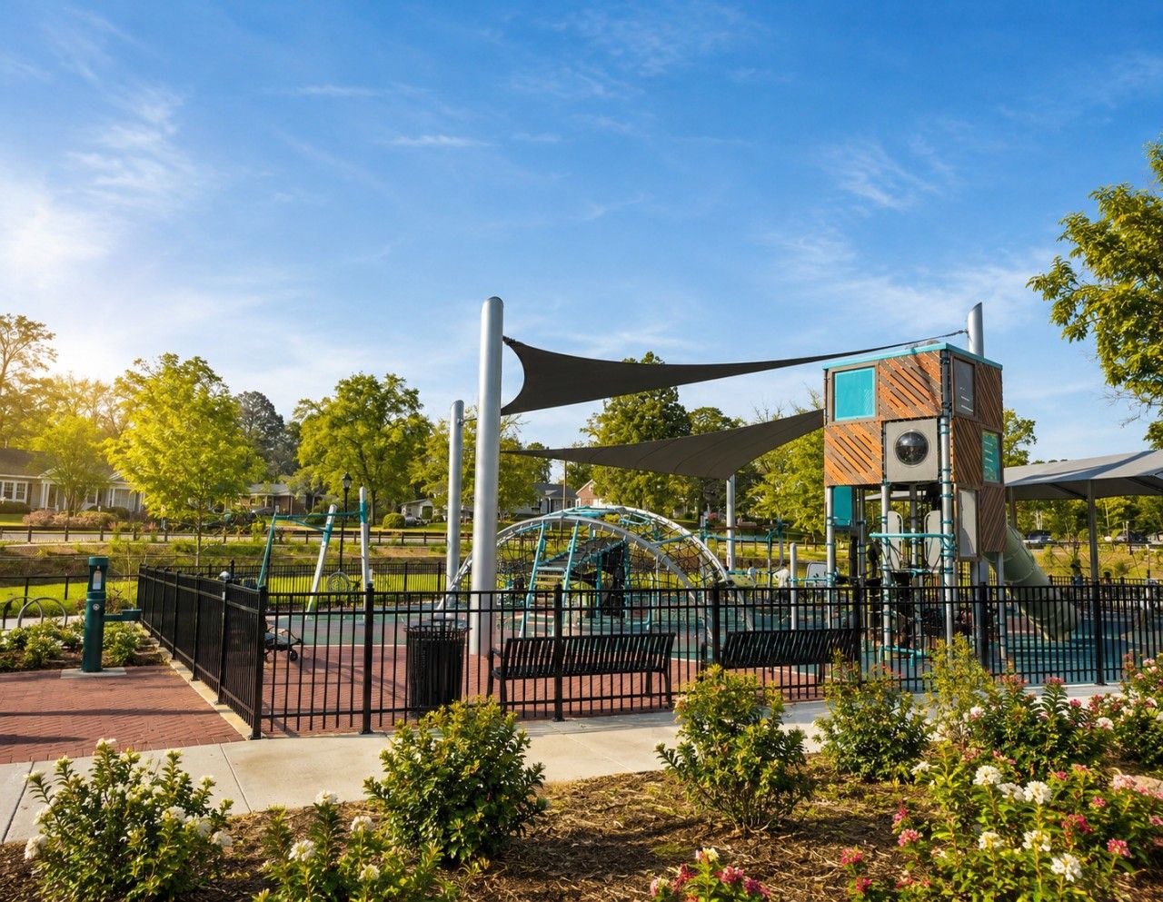 A playground with a climbing structure, a shaded area, and a fenced play area.