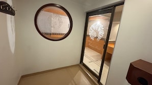 Una camera d'albergo con uno specchio tondo, una porta scorrevole e un elemento decorativo in legno sulla parete.