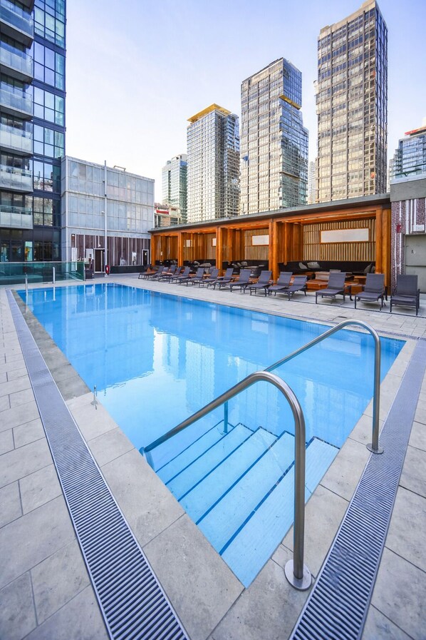Una piscina en la azotea con vistas despejadas de edificios altos circundantes.