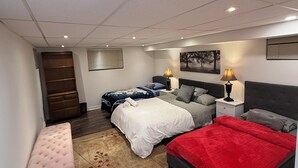 A bedroom with two beds, a bench, and a dresser. - Spacious 2BR Basement • Full Kitchen • Vaughan (Vaughan)