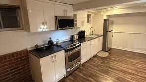 A modern kitchen with white cabinets, stainless steel appliances, and a wooden floor. - Spacious 2BR Basement • Full Kitchen • Vaughan (Vaughan)