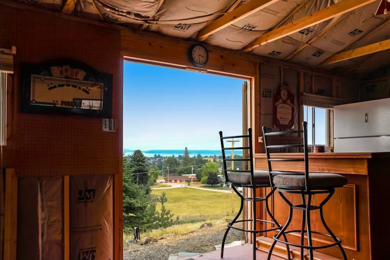 Una cocina con vista a un campo césped y un edificio a lo lejos.