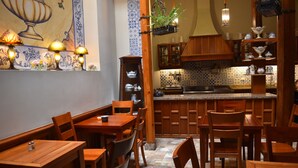Eine traditionelle Küche mit Holzschränken, einer gefliesten Spritzschutzwand und einem Essbereich mit Holztischen und -stühlen.