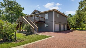 Ein zweistöckiges Haus mit überdachter Veranda und Garage.