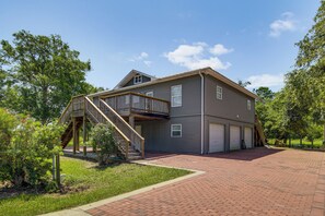 Ein zweistöckiges Haus mit überdachter Veranda und Garage.