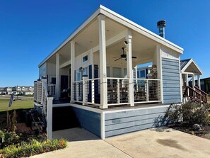 En toetages bygning med en overdækket veranda og skorsten.