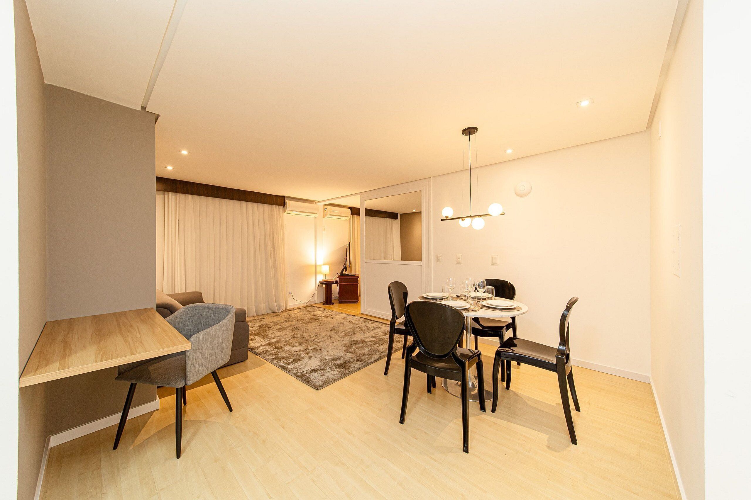 Una sala de estar moderna con comedor, un sofá, una mesa de centro y una alfombra.