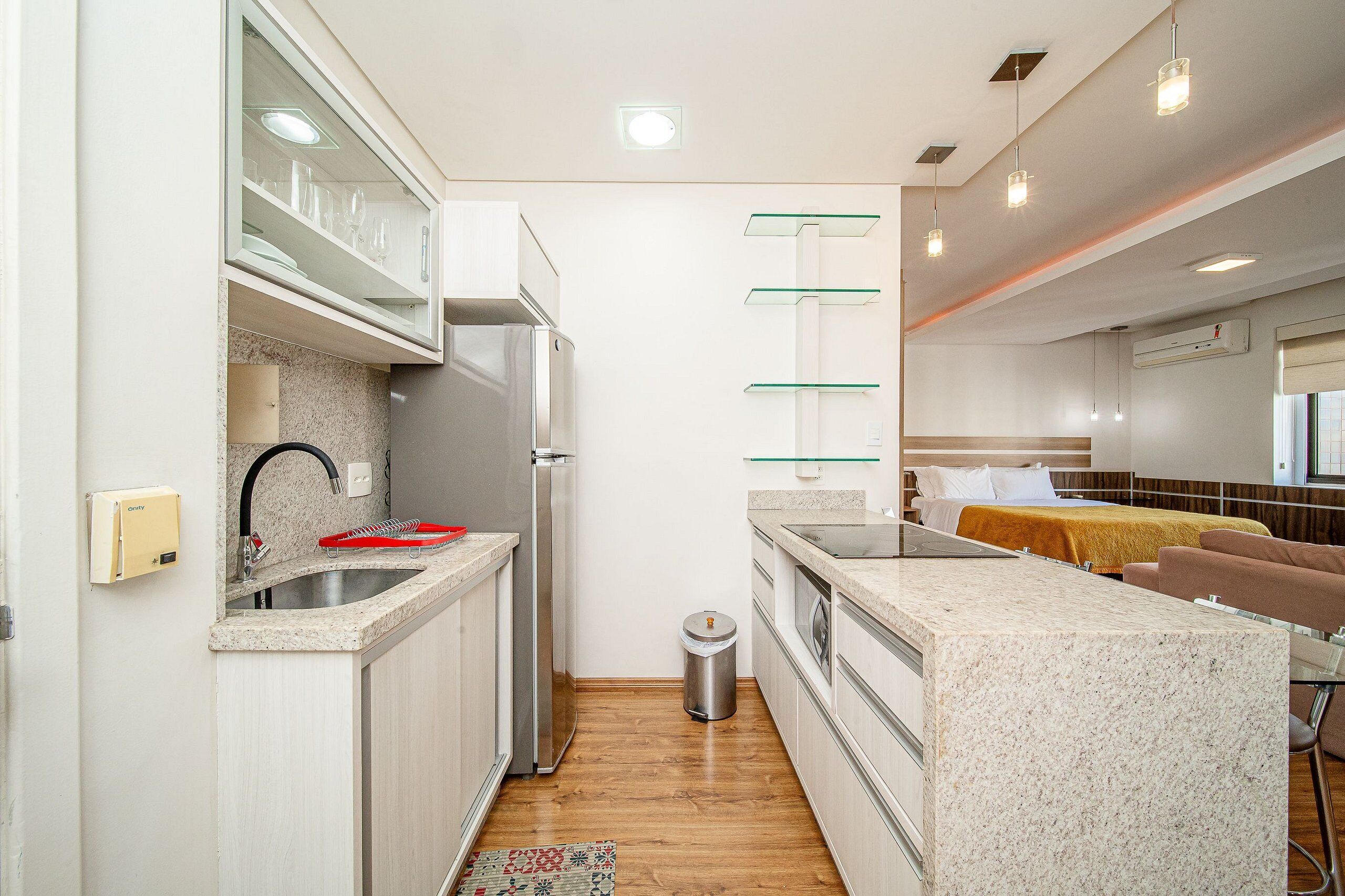 A modern kitchen with a stainless steel refrigerator, a sink, and a countertop with a dish rack.
