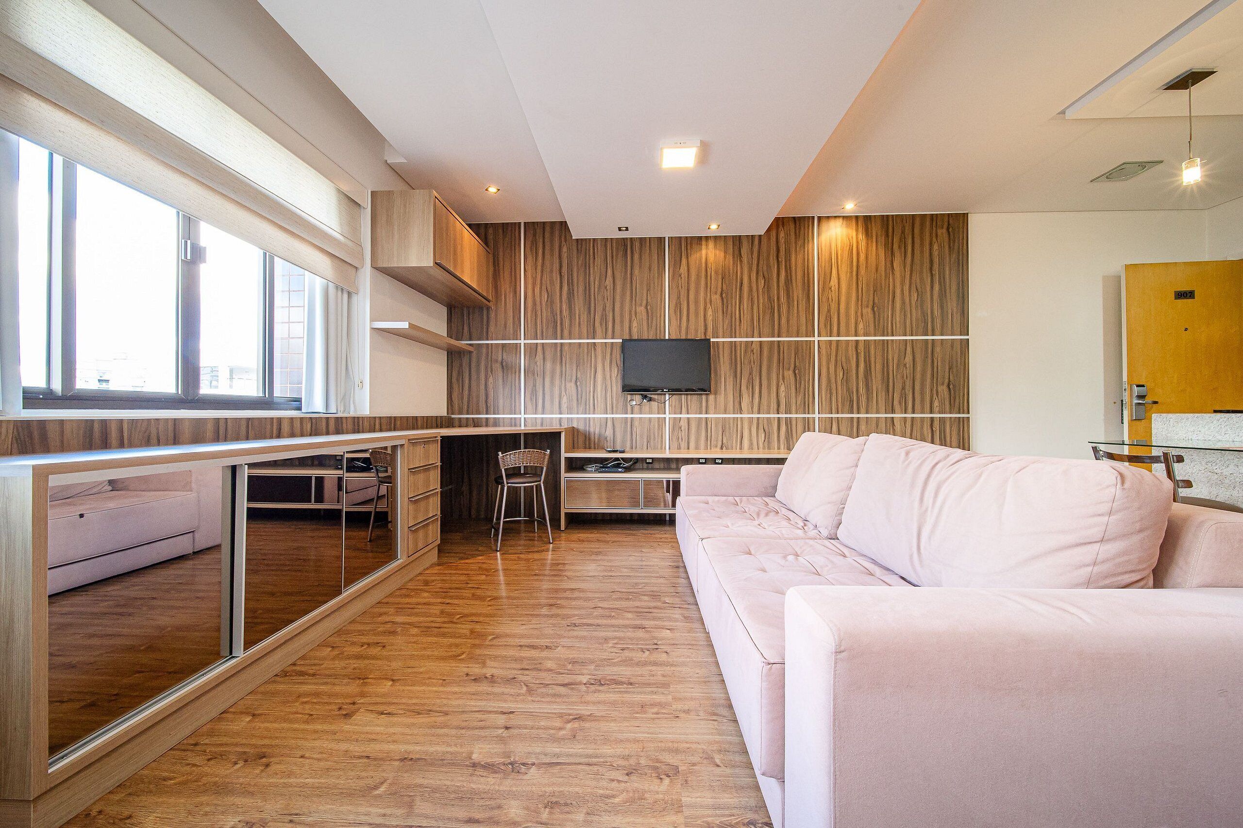 Un interior moderno con un sofá, una televisión y una zona de cocina.