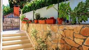 A stone staircase leading to a door with a wrought iron gate. - Stunning apartment in Supetar with WiFi (Supetar)