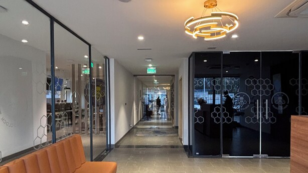 A modern hotel lobby with a long corridor, a reception desk, and a seating area. - Round D Clock (New Delhi)