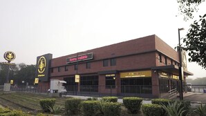 A building with a sign indicating rooms are available, a 2-lingui store, and a visible entrance. - Round D Clock (New Delhi)