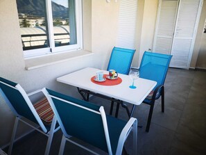 A table with chairs, a window, and a view of a mountain. - BRIGHT APARTMENT IN THE HEART OF PUERTO BANÚS (Marbella)