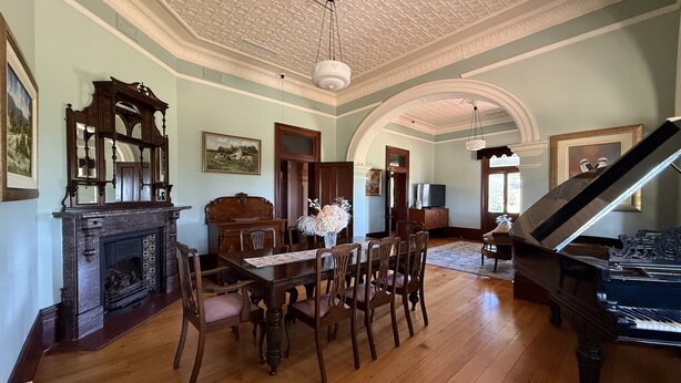 A spacious room with a grand piano, wooden dining table, and chairs. - Kalimna Homestead, Historic Stays, Hunter Valley (Paterson)