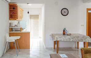 A compact living space with a kitchenette, a dining area, and a small seating area.