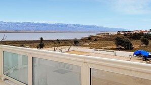 Un balcon avec vue sur un lac et des montagnes.