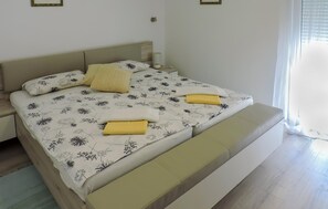 Un dormitorio con cama, mesitas de noche y una ventana con persianas.