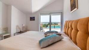 Ein Schlafzimmer mit einem großen Bett, Meerblick und einem Balkon.