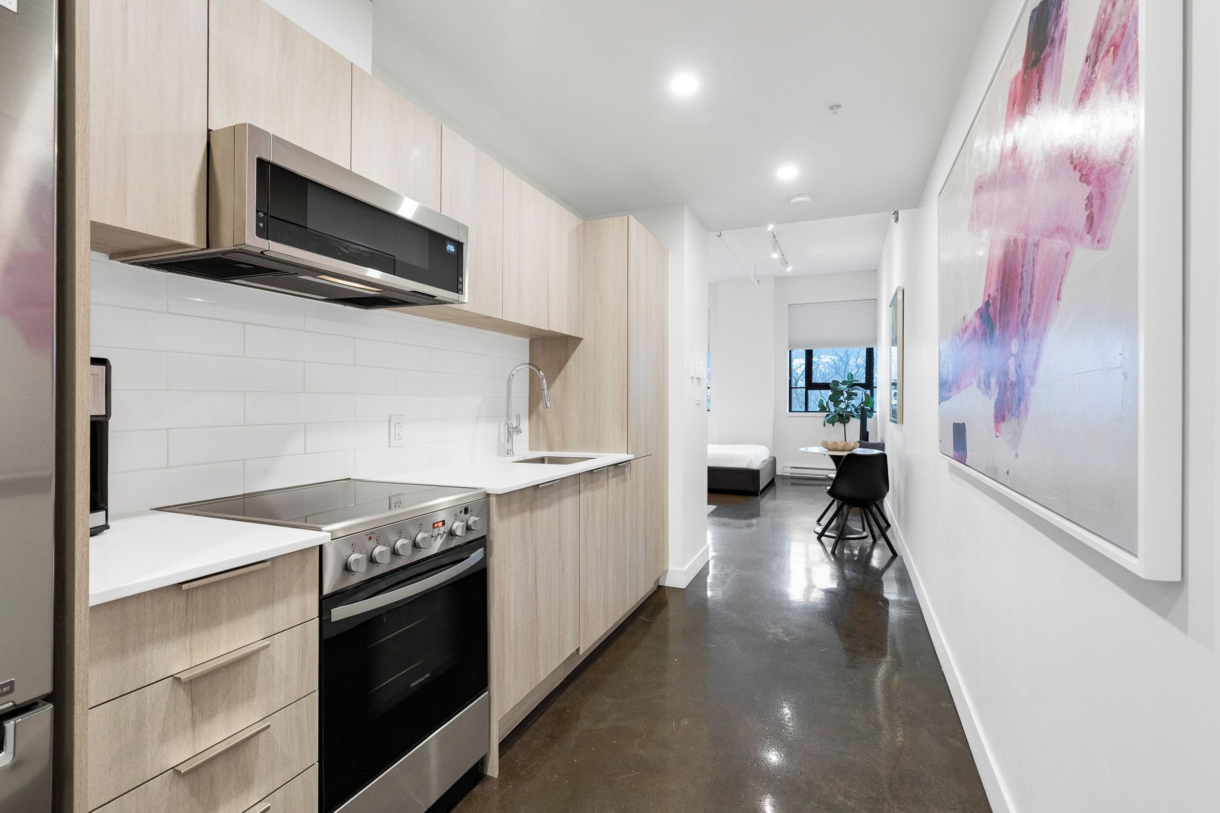 A modern kitchen with a stainless steel stove, wooden cabinets, and a white countertop.