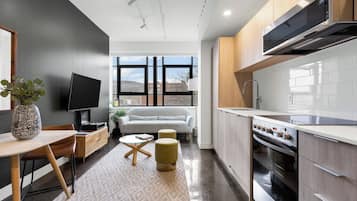 Loft exclusivo | Escritorio, espacio para trabajar con laptop y cortinas blackout