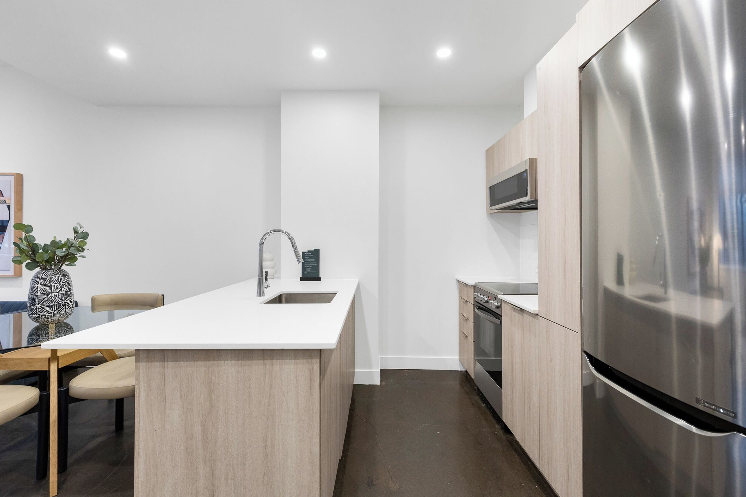 A modern kitchen with a central island, stainless steel appliances, and a minimalist design.