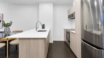 A modern kitchen with a central island, stainless steel appliances, and a minimalist design.