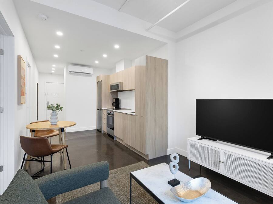 Uma sala de estar moderna com sofá, mesa de centro e televisão de tela plana.
